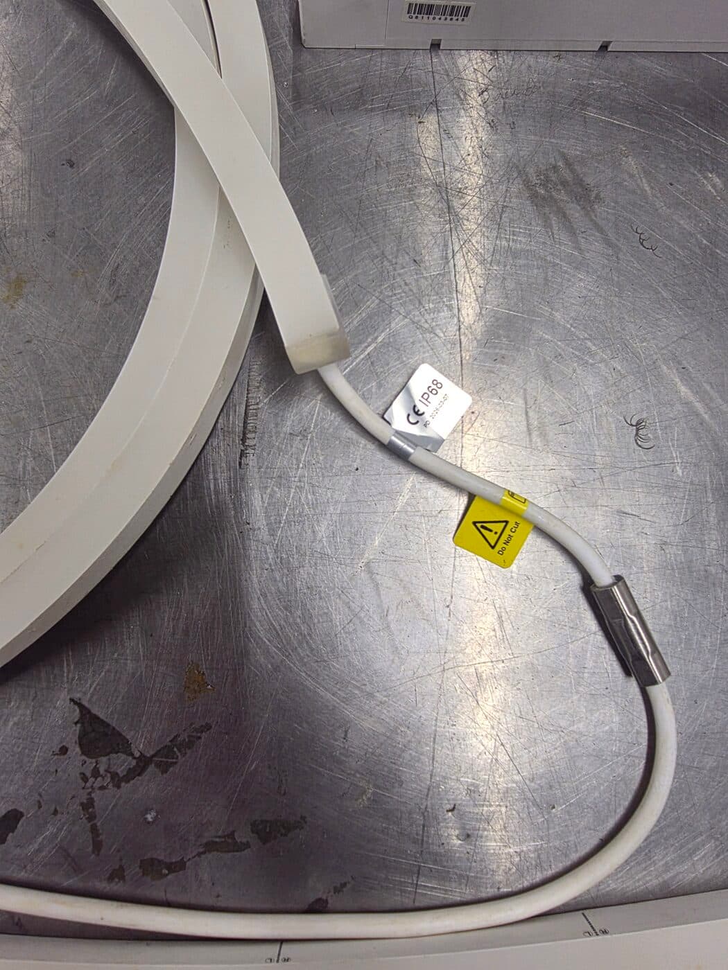 Close-up of the sealed IP68 strip end cap with CE marking and 'Do Not Cut' label on the factory-terminated lead