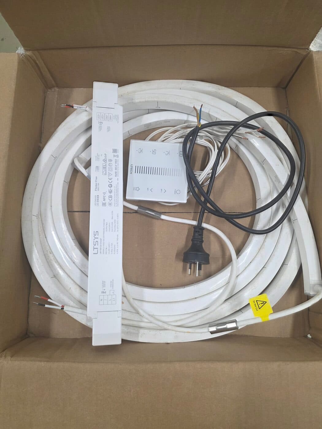 Duskline outdoor LED kit as delivered — coiled white IP68 neon-flex strip, LTECH LED driver, 0–10V wall dimmer and 240V plug lead packed in the box